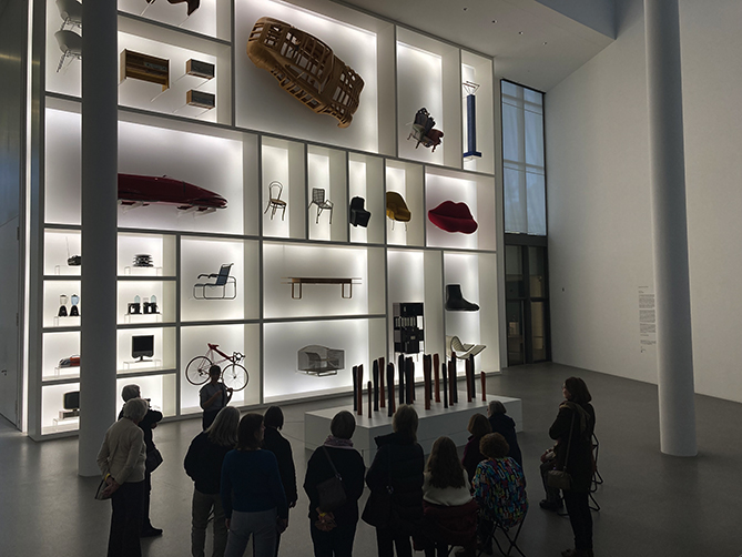 Blick auf die Ausstellungswand der Neuen Sammlung mit verschiedenen Möbeln und Design-Objekten